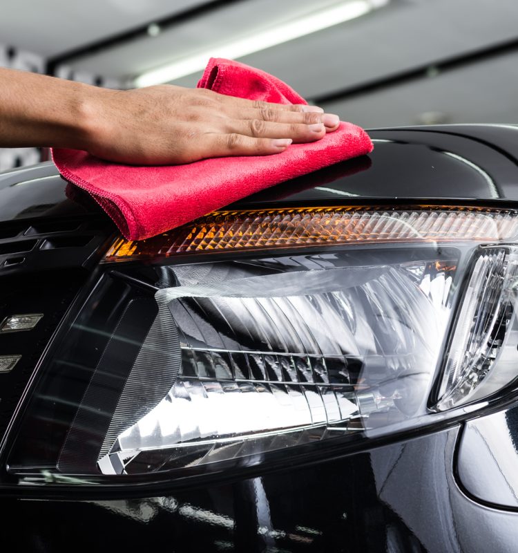 Car detailing series : Worker cleaning black car